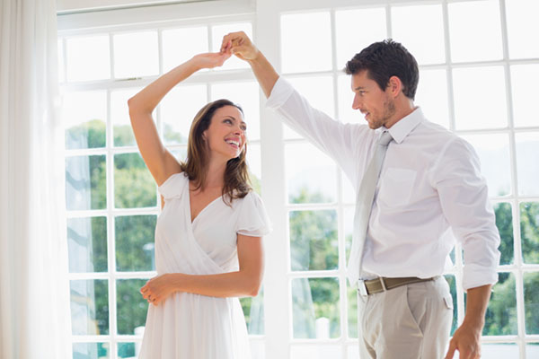 Loving young couple dancing at home